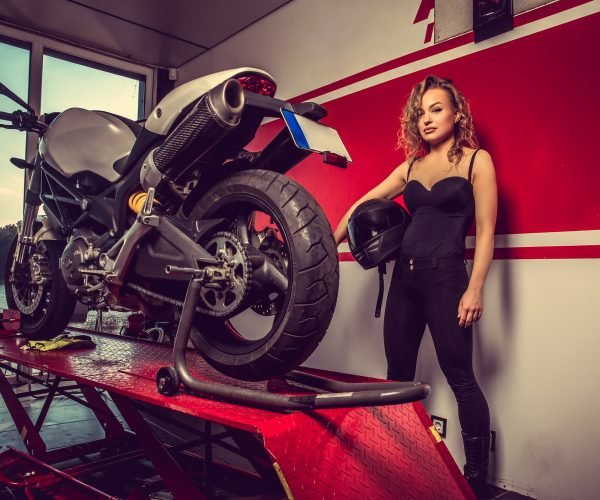 Blond female near motorcycle.